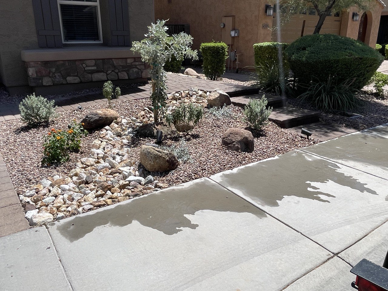 Front yard planting bed rebuilt with a boulder and river-rock creek bed, desert plants, a paver step path and low voltage landscape lights.