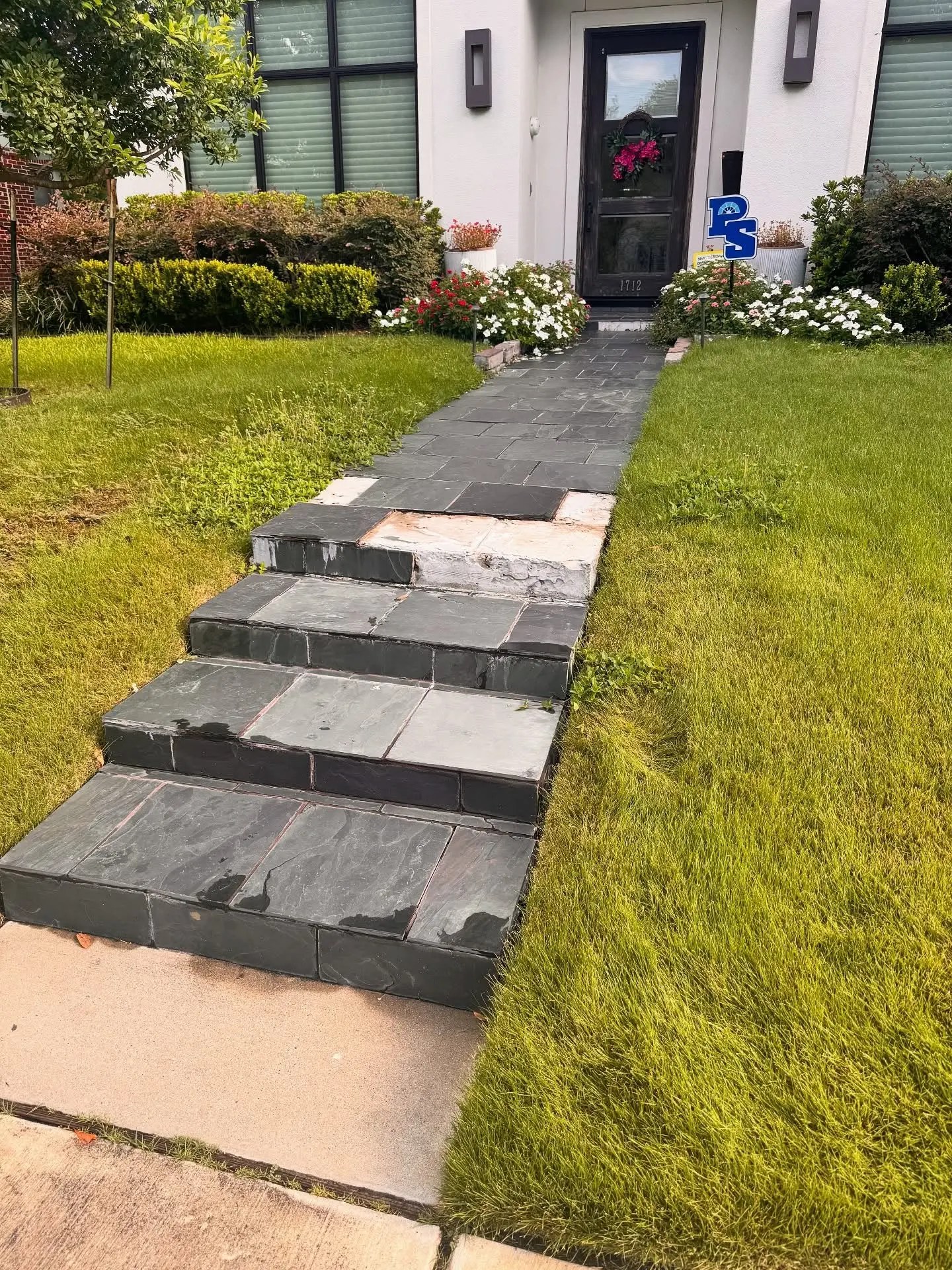 Front walkway and steps of dark slate tiles with several broken and missing treads, before the rebuild.